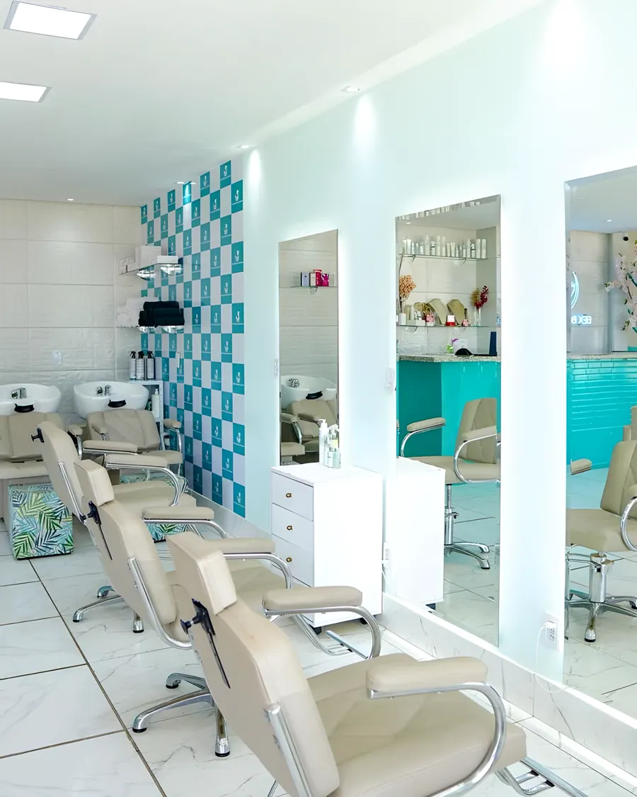 Bancadas de cabelo com espelhos, lavatórios e a parede xadrez verde-água
