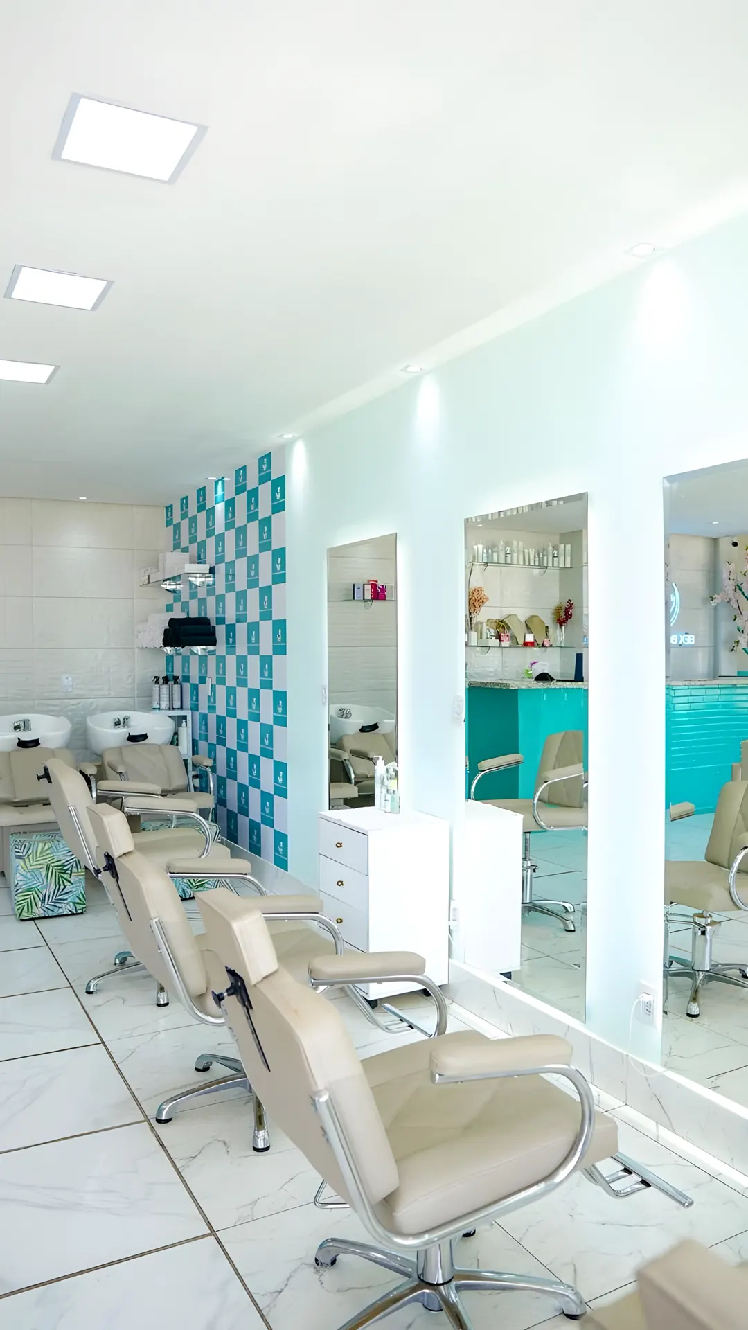 Bancadas de cabelo com espelhos, lavatórios e a parede xadrez verde-água